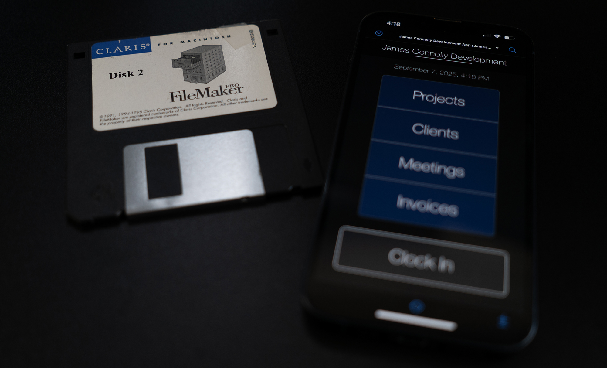Claris FileMaker floppy disk from the 1990s next to a smart phone displaying a Claris FileMaker app from 2025.