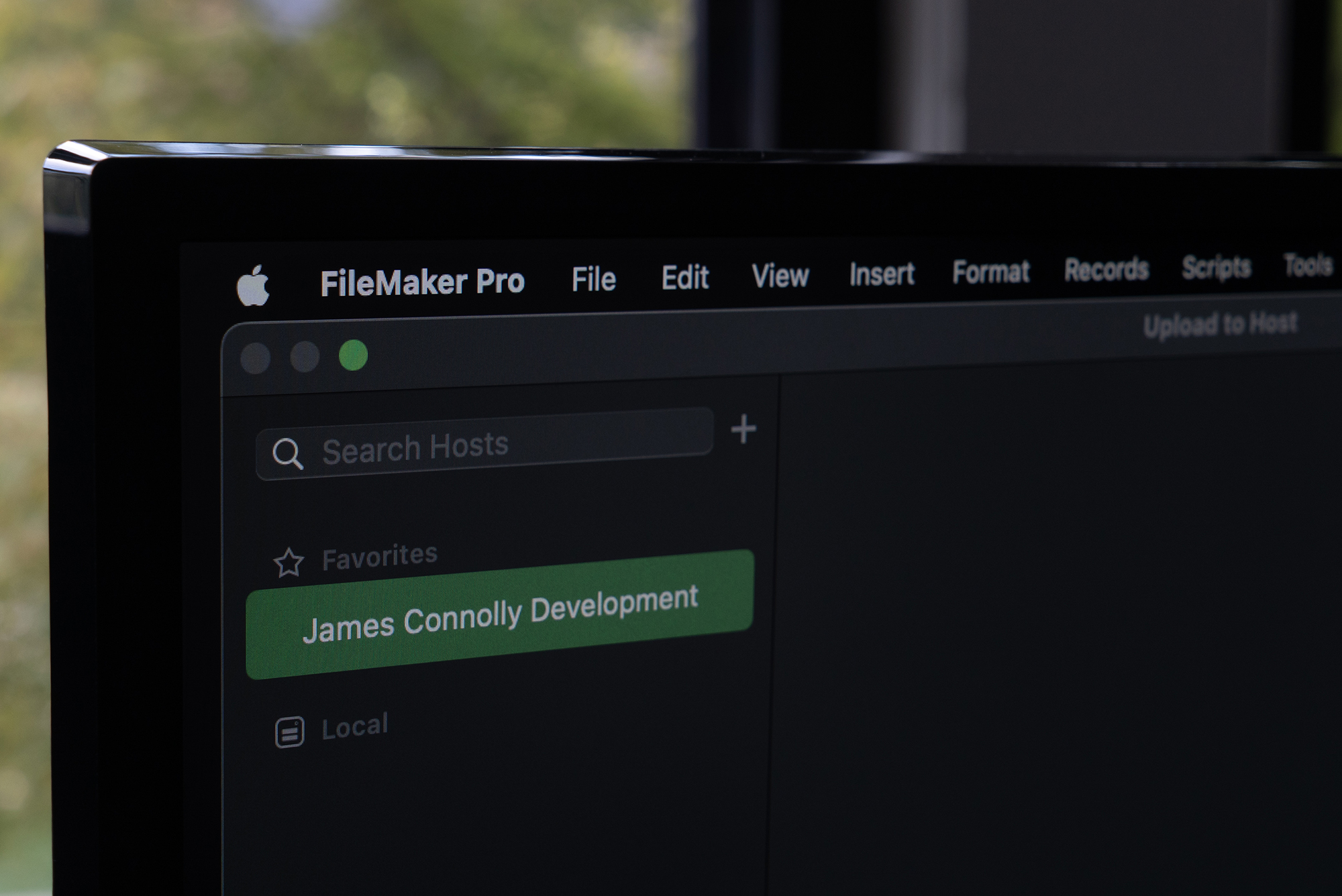 Monitor showing the FileMaker Upload to Host window with 'James Connolly Development' listed under favorite hosts.